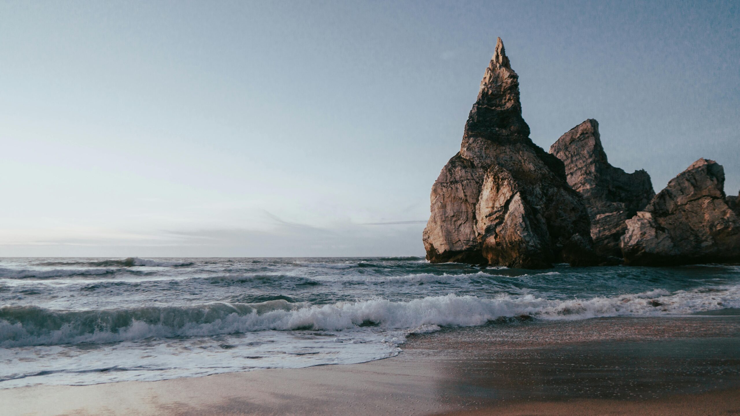 Dramatic rock formations and waves at Praia da Ursa beach, Portugal.